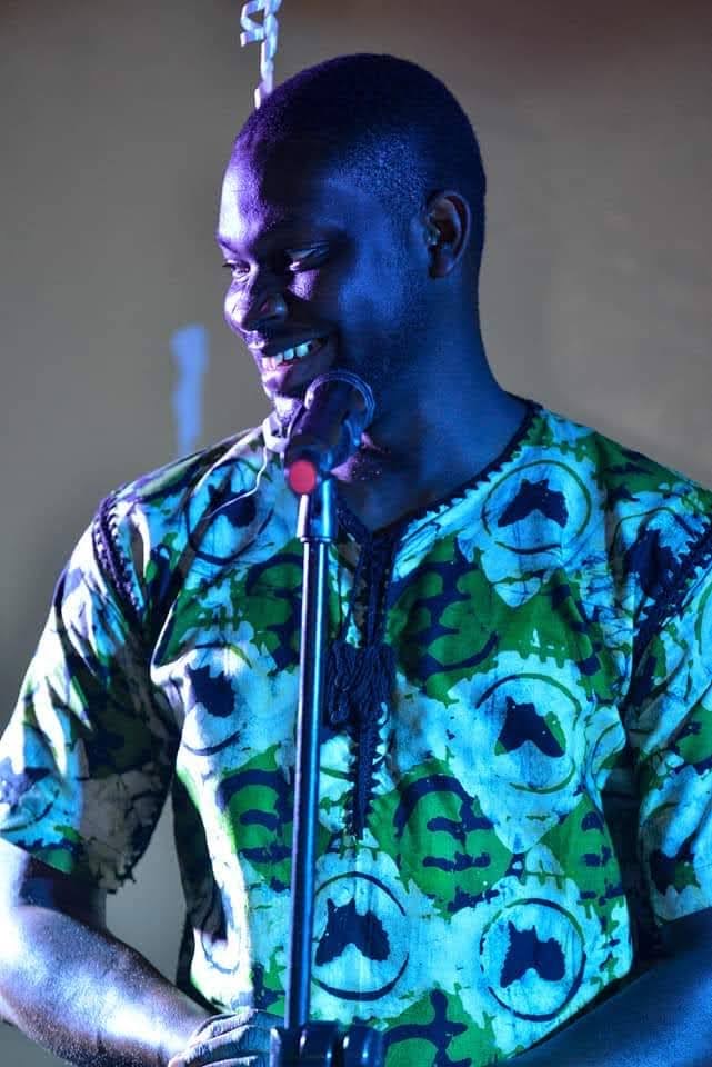 Kwadwo Awortey performing poetry at a microphone